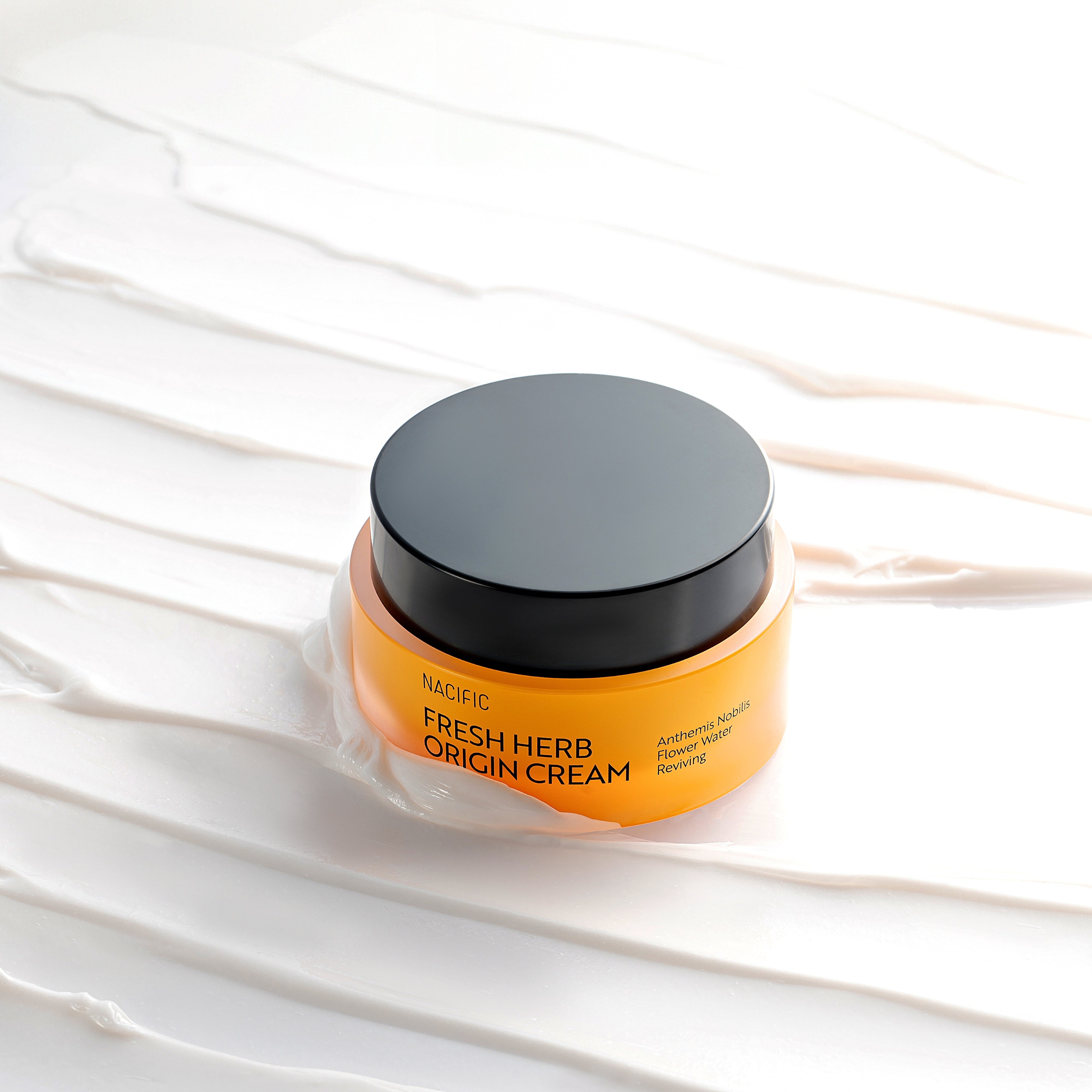 Orange jar of Nacific Fresh Herb Origin Cream on a white textured background