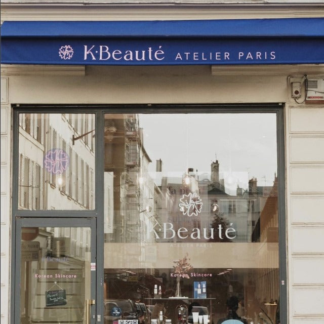 KBeauté Atelier Paris store front with blue awning and glass door.